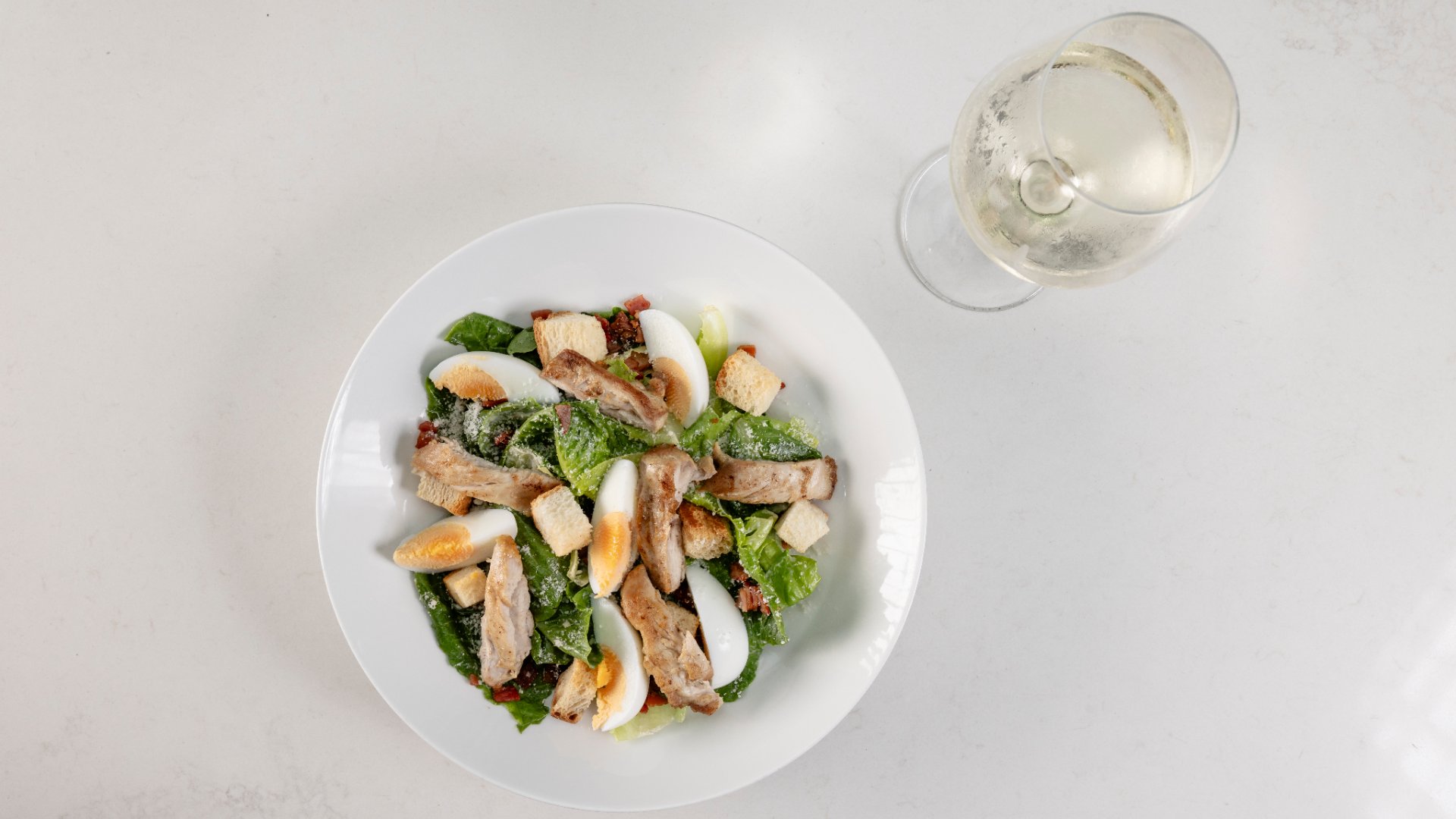 letsdolunch_dinebne2026_thecharles_1. Ceaser salad and wine at The Charles